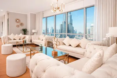 a living room with white furniture and a large window at Elite Royal Apartment - Full Burj Khalifa & Fountain View - King in Dubai