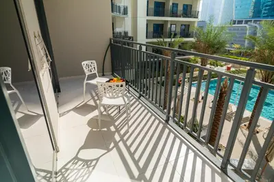 a balcony with chairs and a swimming pool at CitiHome -1BR with Balcony & Pool View in Zada Tower in Dubai