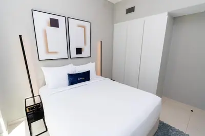 a bedroom with a white bed and two pictures on the wall at CitiHome - Newly Furnished Apartment in Business Bay in Dubai