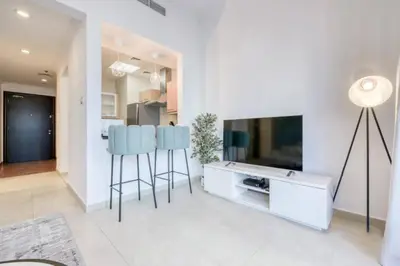 a living room with two blue bar stools and a television at Luxury 1 Bedroom Marina View, Sleeps 6, 1 Min to Metro in Dubai