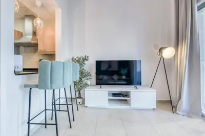 a living room with a tv and two bar stools at Luxury 1 Bedroom Marina View, Sleeps 6, 1 Min to Metro in Dubai