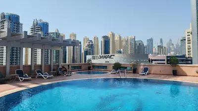 a swimming pool on top of a building with a city at Luxury 1 Bedroom Marina View, Sleeps 6, 1 Min to Metro in Dubai
