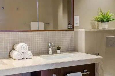a bathroom with a sink and a mirror and towels at Chic & Trendy 3BR+kid's in Vibrant Downtown Dubai in Dubai