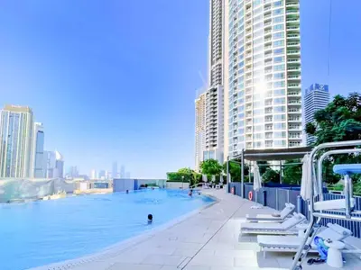 a large swimming pool in a city with buildings at Chic & Trendy 3BR+kid's in Vibrant Downtown Dubai in Dubai