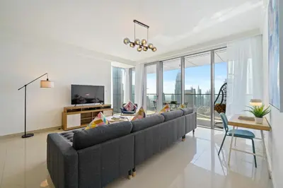 a living room with a large couch and a tv at Chic & Trendy 3BR+kid's in Vibrant Downtown Dubai in Dubai