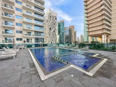 a large swimming pool in front of a building at Silkhaus luxurious 1BDR in AG Tower, Business Bay in Dubai
