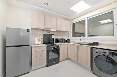 a kitchen with a refrigerator and a dishwasher at Silkhaus luxurious 1BDR in AG Tower, Business Bay in Dubai