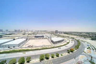 an aerial view of a highway with a city in the background at Incredible Studio at Mesk 1 Midtown Dubai Production City by Deluxe Holiday Homes in Dubai