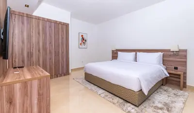 a bedroom with a large bed and a television at Pyramisa Hotel Apartments in Dubai