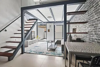 a living room with a staircase and a brick wall at ALiving Duplex Studio I Aria Residence by Grovy, JVC in Dubai