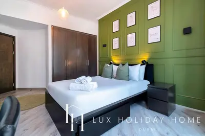 a bedroom with a bed with two towels on it at LUX The Dubai Marina View Suite in Dubai
