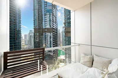 a bedroom with a balcony with a view of a city at LUX The Dubai Marina View Suite in Dubai