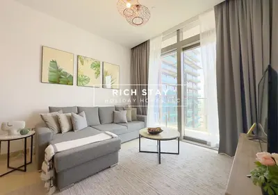 a living room with a couch and a large window at Phenomenal 1BR in Marina Gate 2,Full Marina View in Dubai