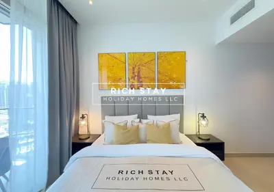 a bedroom with a bed with two lamps and a window at Phenomenal 1BR in Marina Gate 2,Full Marina View in Dubai