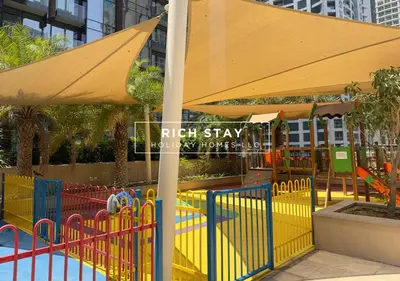 a play area with an umbrella and a playground at Phenomenal 1BR in Marina Gate 2,Full Marina View in Dubai