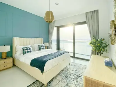 a bedroom with a large bed and a large window at Trophy 2BDR Sandy Shores Retreat with Panoramic Sea View & Private Beach Access in Dubai