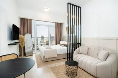 a living room with a couch and a bed at Cozy studio at Bloom Height - JVC in Dubai