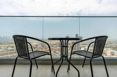 two chairs and a table in front of a window at Cozy studio at Bloom Height - JVC in Dubai