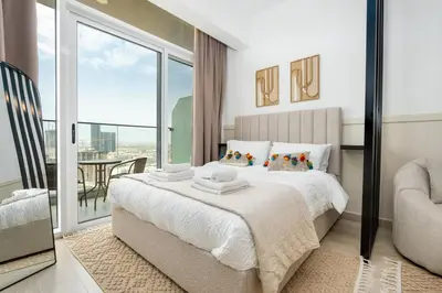 a bedroom with a large bed and a balcony at Cozy studio at Bloom Height - JVC in Dubai