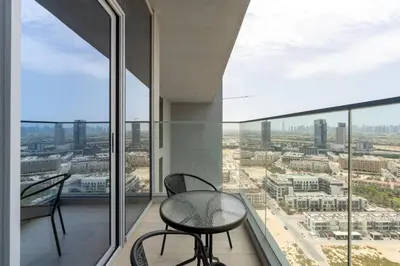 a balcony with a table and chairs and a view of a city at Cozy studio at Bloom Height - JVC in Dubai