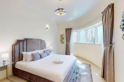 a bedroom with a large white bed and a window at Vacationer I Premium 3 Bedroom Apartment I Close to Marina Promenade & JBR Beach I Prime Location in Dubai