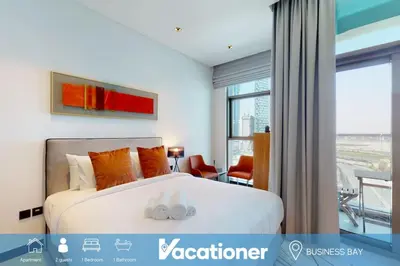 a bedroom with a large white bed with orange pillows at 15 Northside - Chic Studio in Dubai
