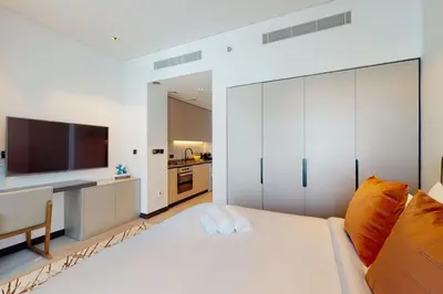a bedroom with a large white bed and a television at 15 Northside - Chic Studio in Dubai