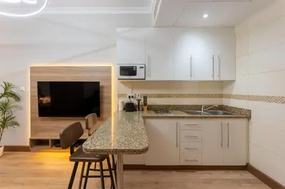 a kitchen with white cabinets and a counter top at Saba Tower 3 - Elegant Studio Apartment in Dubai