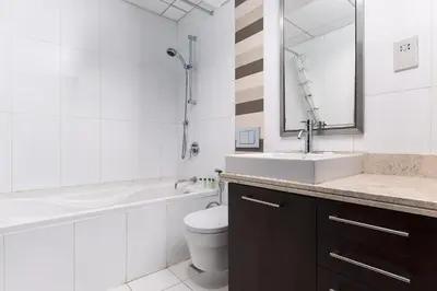 a bathroom with a sink and a toilet and a mirror at BellaVista - Spectacular - 2 BR Penthouse - Boulevard Central - Panoramic Terrace & Burj Khalifa View in Dubai