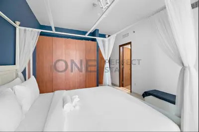 a bedroom with a white bed and a wooden wall at Lake View All Bills Included Fully furnished in Dubai