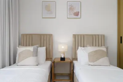 two beds sitting next to each other in a room at Maison Privee - Graceful Apt in Prestigious Dubai Hills close to the Golf Course in Dubai