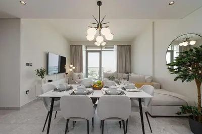 a dining room and living room with a table and chairs at Maison Privee - Graceful Apt in Prestigious Dubai Hills close to the Golf Course in Dubai