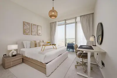 a white bedroom with a bed and a desk and a desk at Maison Privee - Graceful Apt in Prestigious Dubai Hills close to the Golf Course in Dubai