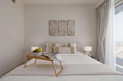 a white bedroom with a bed and a table at Maison Privee - Graceful Apt in Prestigious Dubai Hills close to the Golf Course in Dubai