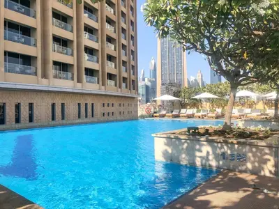 a large blue swimming pool in front of a building at GuestReady - Fashion Avenue | Burj Khalifa View in Dubai