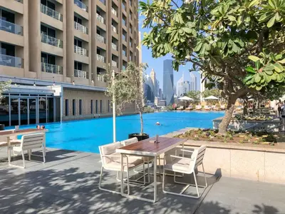 a table and chairs in front of a swimming pool at GuestReady - Fashion Avenue | Burj Khalifa View in Dubai