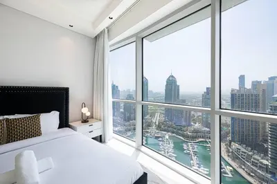 a bedroom with a white bed and large windows at Magnificent - Luxurious 3 BR with Marina View in Dubai