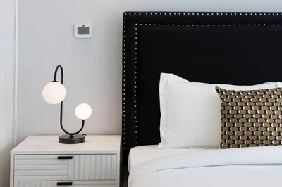 a bed with a black headboard and a night stand with a lamp at Magnificent - Luxurious 3 BR with Marina View in Dubai