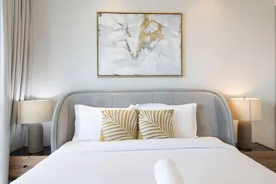 a bedroom with a bed with pillows and a painting at Magnificent - Luxurious 3 BR with Marina View in Dubai