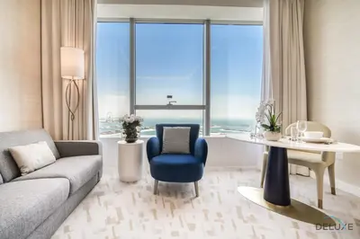 a living room with a couch and a table and a chair at Heavenly Studio at The Palm Tower Palm Jumeirah by Deluxe Holiday Homes in Dubai