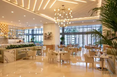 a restaurant with tables and chairs and a chandelier at Heavenly Studio at The Palm Tower Palm Jumeirah by Deluxe Holiday Homes in Dubai