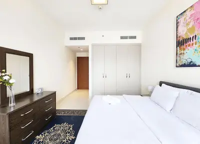 a bedroom with a bed and a dresser and a mirror at RH- Captivating Skyline View, 02BR Near Clemance Medical Center in Dubai