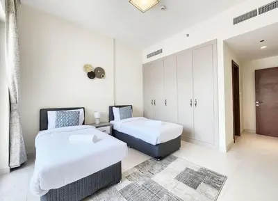 two beds in a room with white walls at RH- Captivating Skyline View, 02BR Near Clemance Medical Center in Dubai
