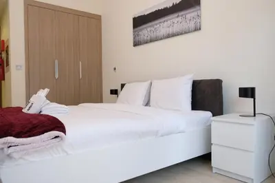 a bedroom with a large white bed with white sheets at Mira Holiday Homes - Cozy studio in Meydan in Dubai