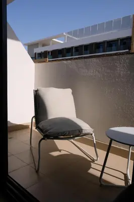 a chair sitting on a balcony with a table at Mira Holiday Homes - Cozy studio in Meydan in Dubai