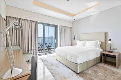 a hotel room with a bed and a balcony at ALiving Elite 2BR I Burj Khalifa View I Paramount Towers, 6102 in Dubai