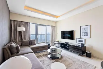 a living room with a couch and a tv at ALiving Elite 2BR I Burj Khalifa View I Paramount Towers, 6102 in Dubai