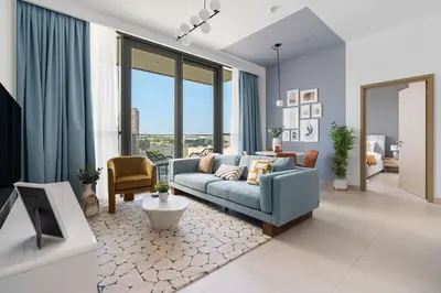 a living room with a blue couch in a room at Silkhaus modern 1BDR in Downtown with balcony, pool, gym in Dubai