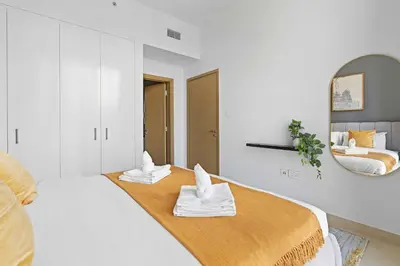 a white bedroom with a bed with towels on it at Silkhaus modern 1BDR in Downtown with balcony, pool, gym in Dubai