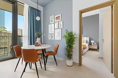 a dining room with a table and chairs and a bedroom at Silkhaus modern 1BDR in Downtown with balcony, pool, gym in Dubai